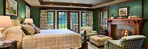 luxury master bedroom of restored historic Montana cabin towards windows and views of Swan Lake
