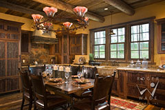 colorful kitchen and dining room of small luxury log home with rustic custom cabinets by The Old World Cabinet Company