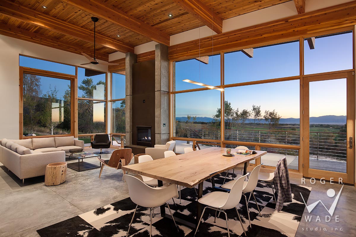photo of contemporary interior design, living room looking out windows to mountain view at twilight, alta, wy