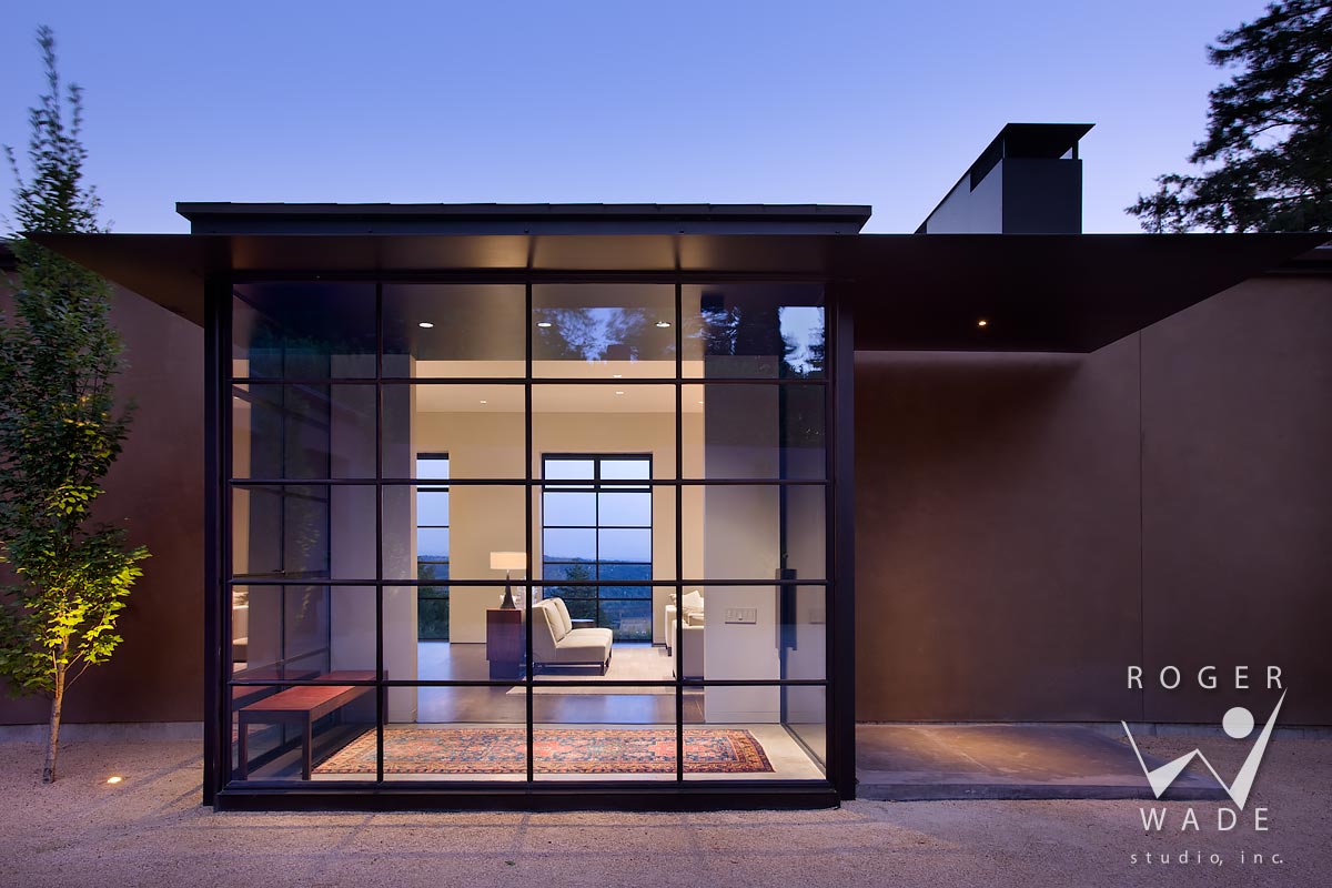 modern architectural photography, front entry of steel and glass, looking into living room at twilight, portland, or