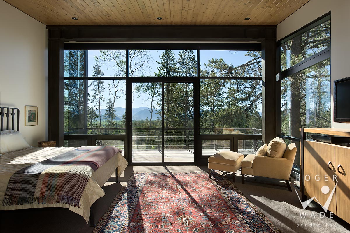 image of contemporary interior design, master bedroom looking out windows to forest view, wilson, wy