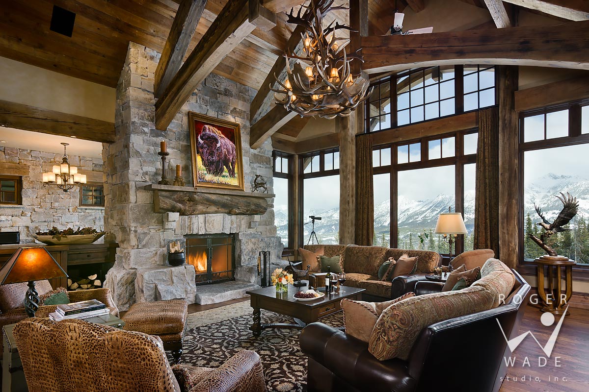 living room toward fireplace and windows looking out to mountain view, big sky, mt