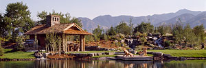 rustic timber pavillion next to landscaped pond and waterfall