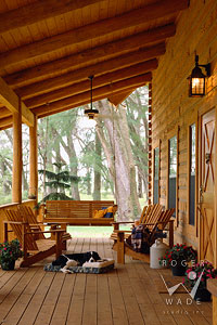 front porch of milled log home with sleeping dog