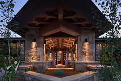 porte-cochre towards entry of luxury mountain stone and timber frame lodge