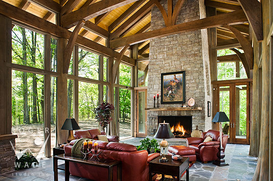 luxury treehouse living room of timberframe home with glass walls and whole tree trunk posts