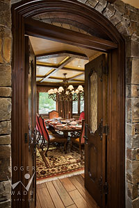dining room of luxury mountain home through arched wooden doorway