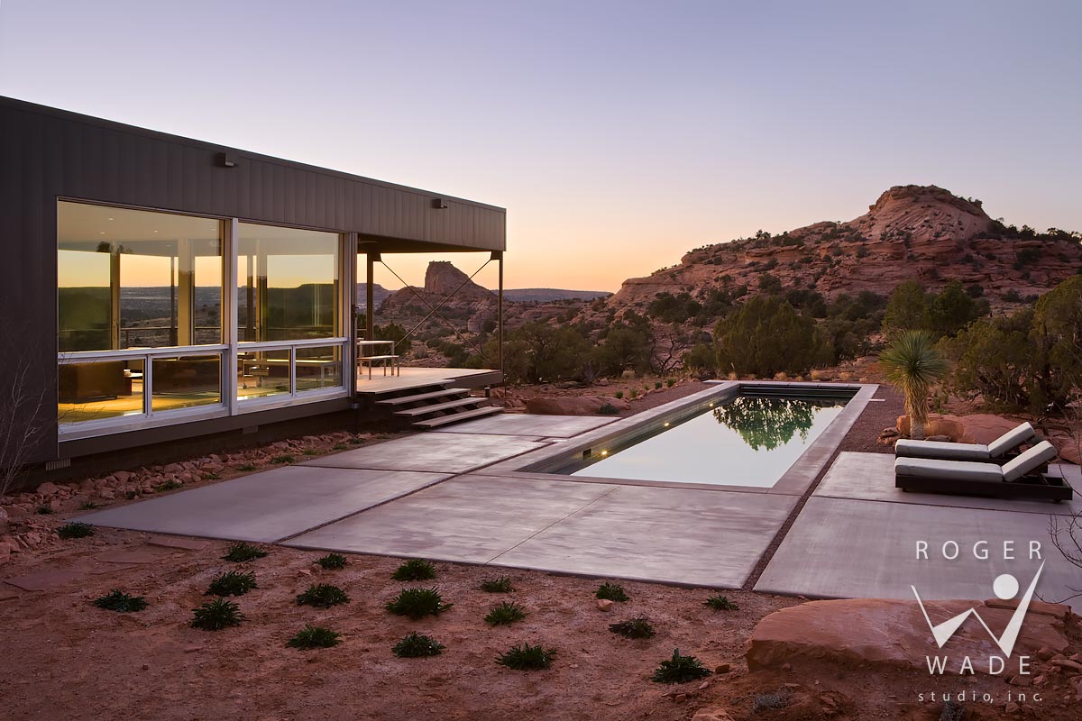 photo of contemporary modular architecture, looking over pool area toward living area wing at twilight, moab, ut