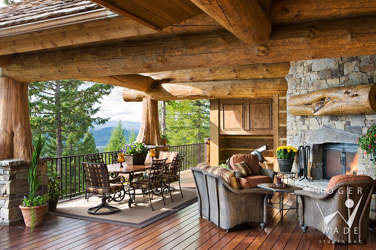 log cabin stock photo, rear covered deck with fireplace looking out to mountain view, whitefish, mt