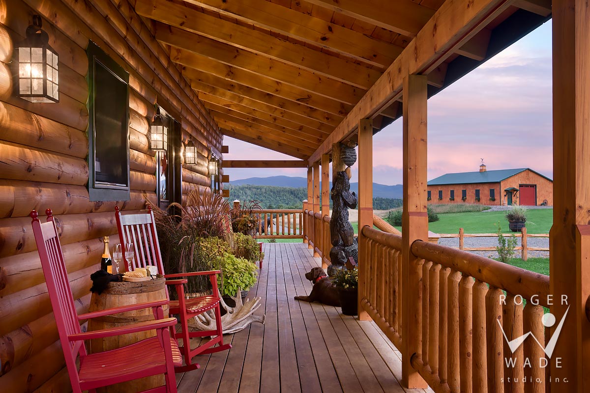 log cabin stock image, front porch with dog at twilight, looking out to farm view, stewartsville, nh